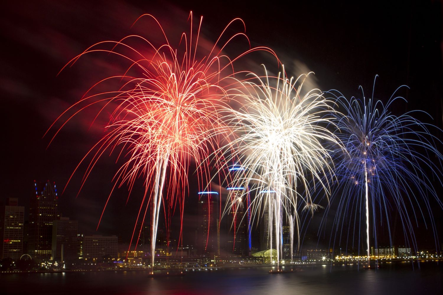 Red, white, and blue 4th of July fireworks at night.